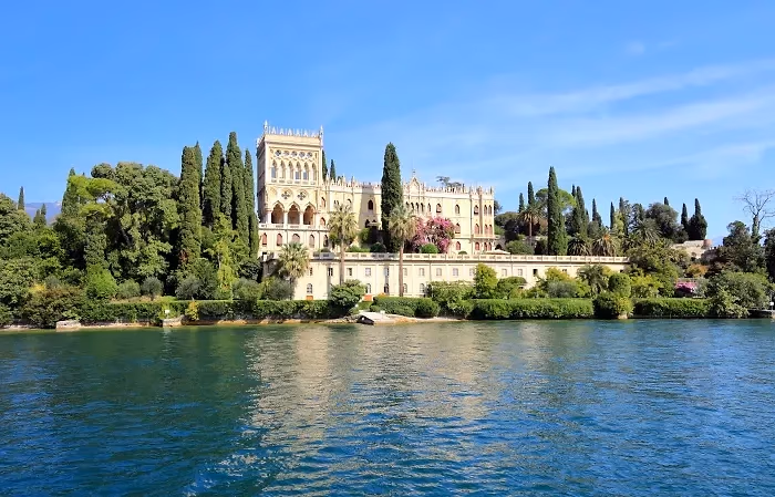 Het eiland Isola del Garda met de neogotische villa tussen cipressen en tuinen aan het water