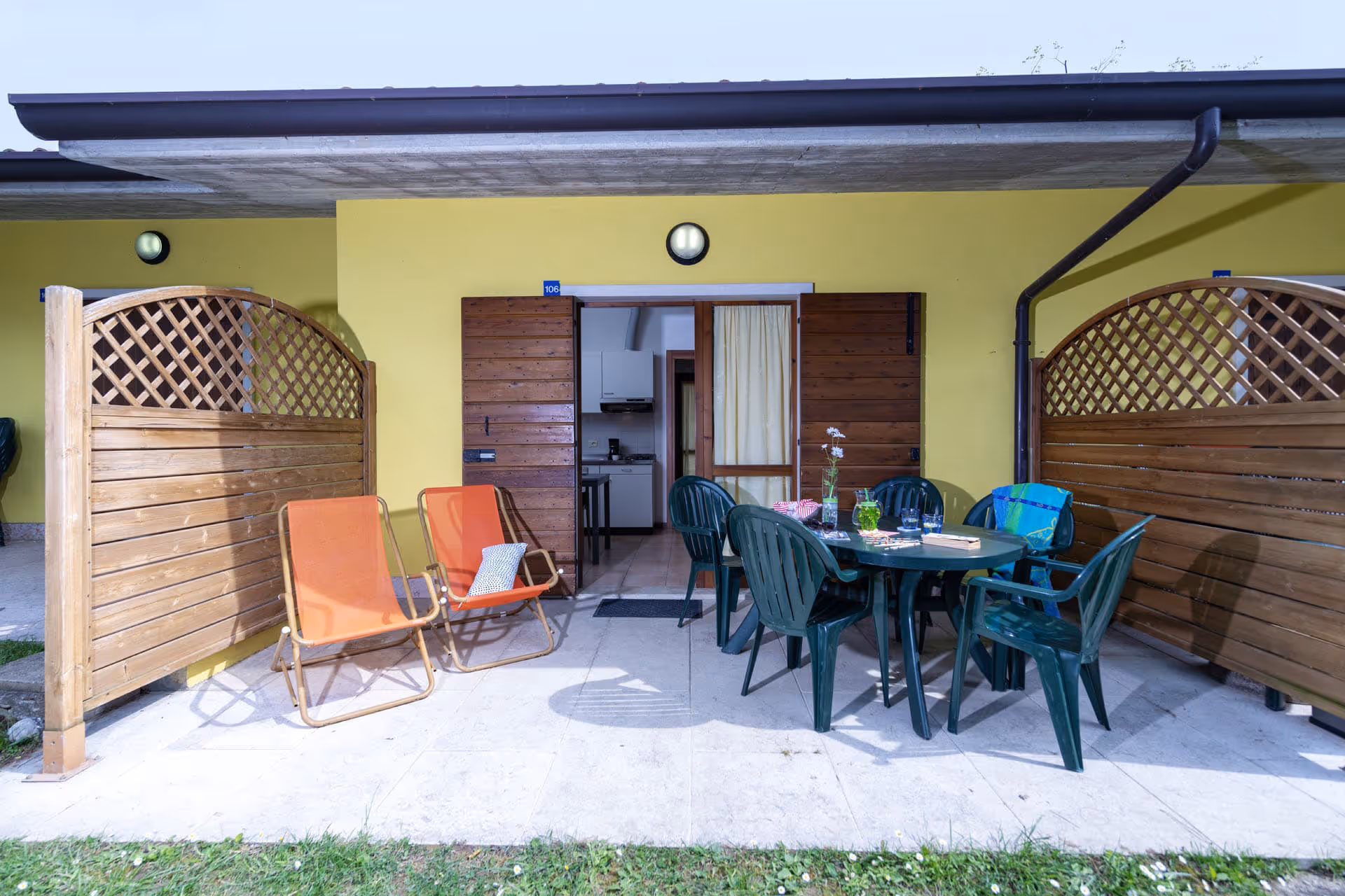 Terras van bungalow Amore in het Catullo-deel van Camping Piani di Clodia met tuinmeubilair