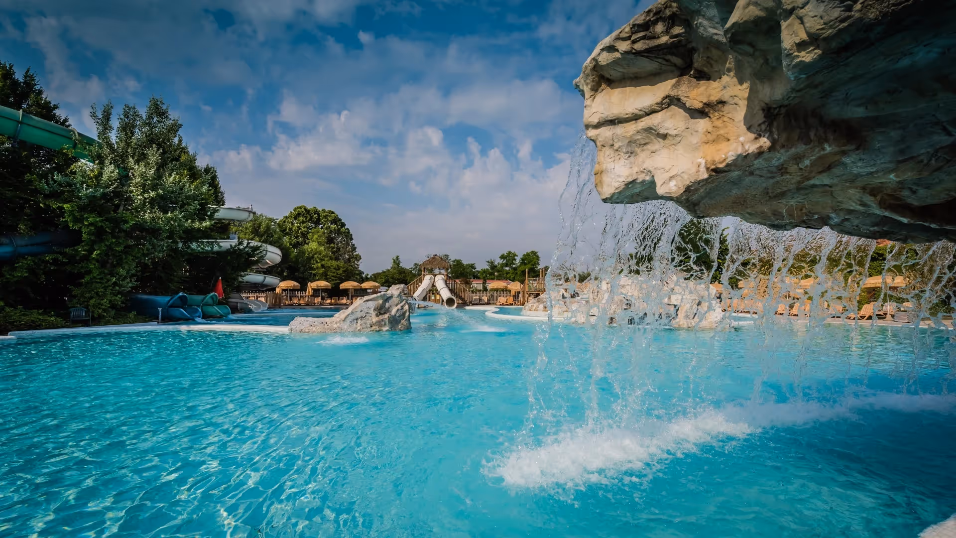 Lagunezwembad met rotspartij en waterval bij de Luxury Lagoon-maxicaravans op Camping Piani di Clodia