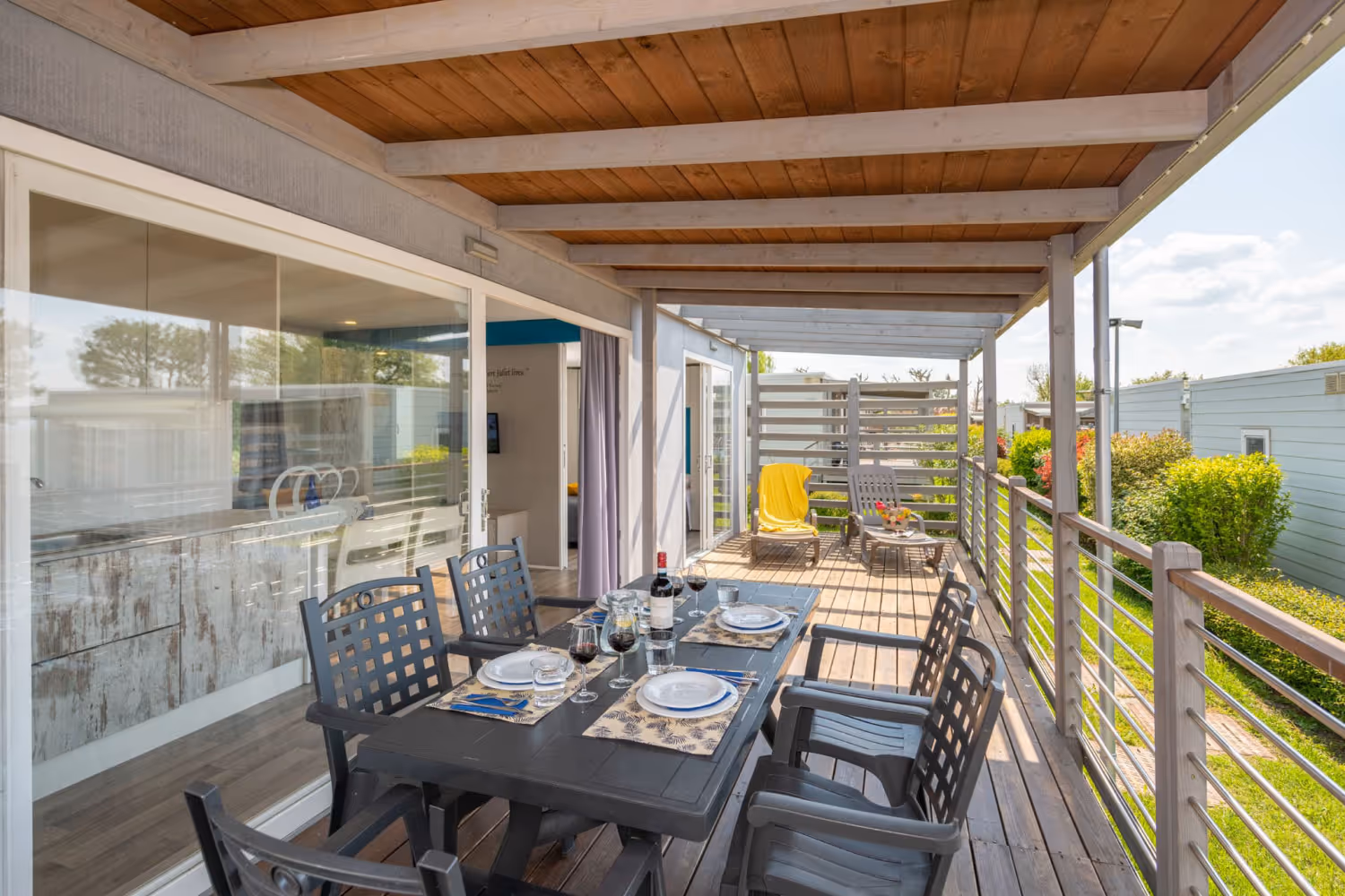 Overdekte veranda met eettafel van maxicaravan Romeo op Camping Piani di Clodia