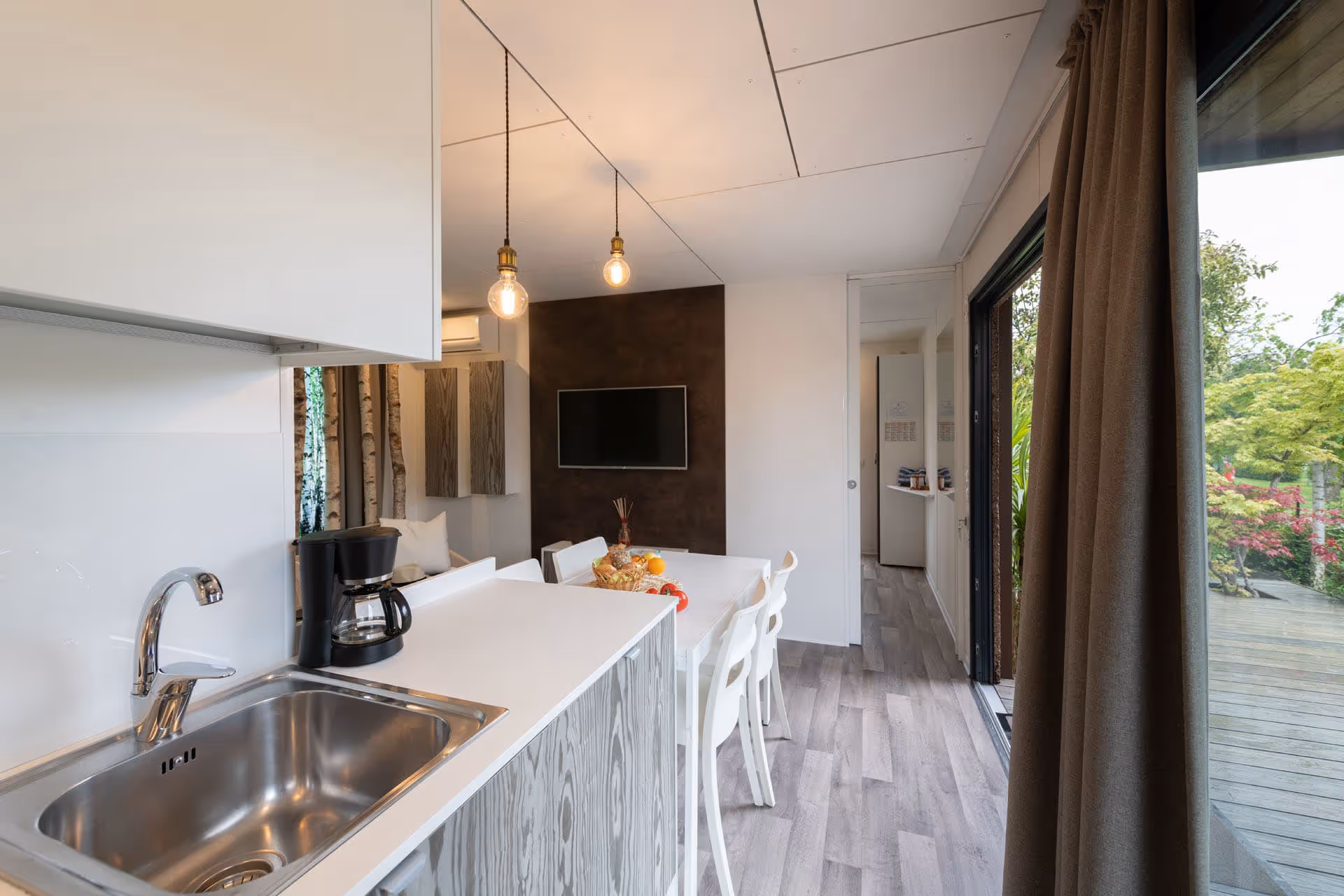 Licht interieur van de Naturalgreen Garden-maxicaravan met omheinde tuin op Camping Piani di Clodia